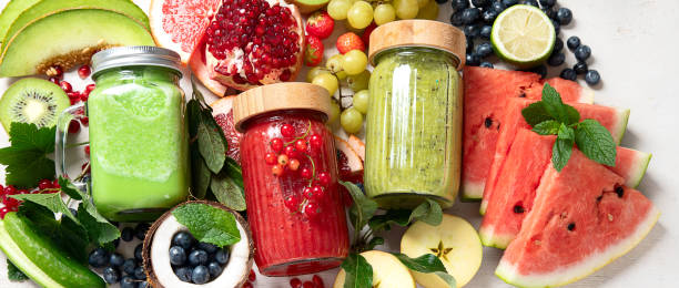 istock Fresh fruit and vegetable smoothies or juice  with various ingredients on light background. 1521429721
