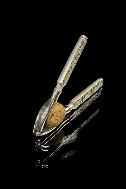 istock Tweezers for walnut with reflected in black glass 152143586