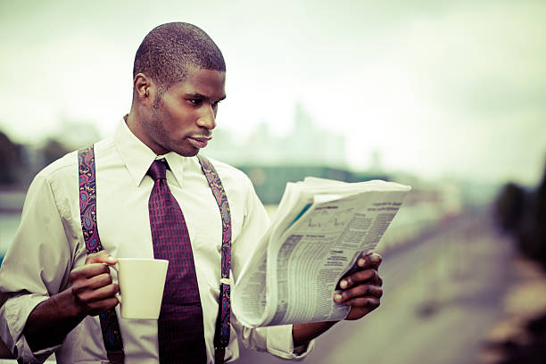 istock Businessman in braces reading newspaper and drinking coffee 152145157