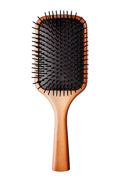 Photo of A bristled brown hair brush against a white background