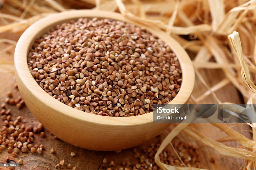 A large wooden bowl of buckwheat Dry buckwheat groats on wooden bowl Buckwheat Stock Photo