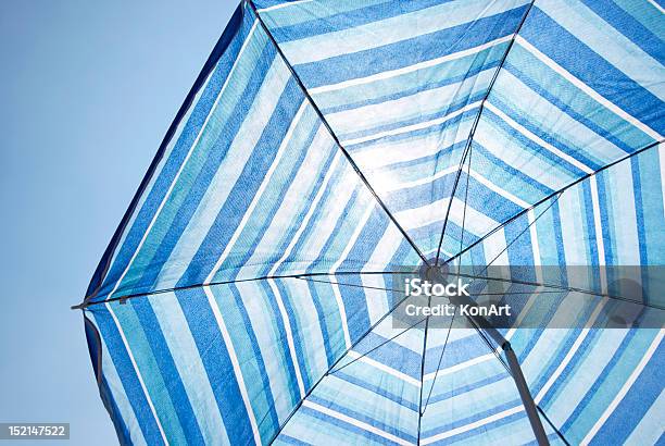 Blue Backlit Parasol Against Plain Sky Stock Photo - Download Image Now - Beach Umbrella, Below, Angle