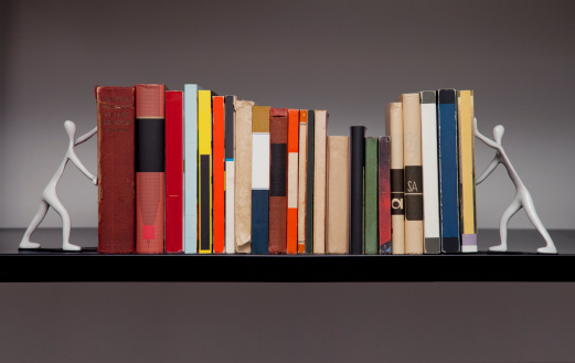 Studio photo of a single shelf of books with white bookends.