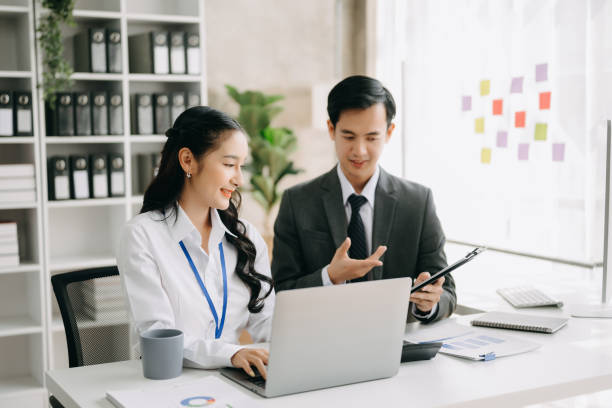 istock Two business workers talking on the smartphone and using laptop at the office. 1521487157
