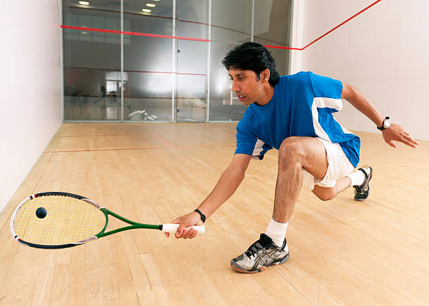 istock A squash player kneels down to hit a ball 152148868