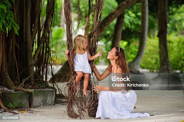 Foto de Linda Jovem Mãe E Sua Filha Pequena No Parque Tropical e mais fotos de stock de Balanço - Equipamento de Playground