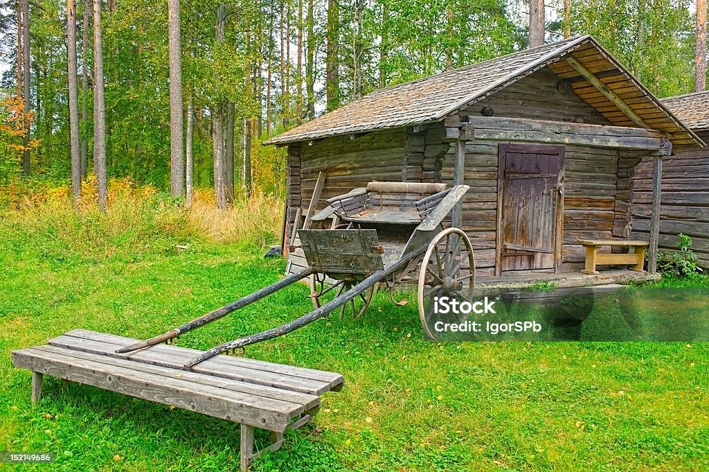 Vecchio carrello in legno Fienile davanti di log - Foto stock royalty-free di Abbandonato