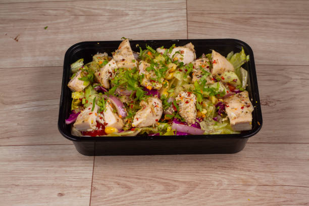 istock Herb Roast Chicken Salad in black container on wooden background 1521519577