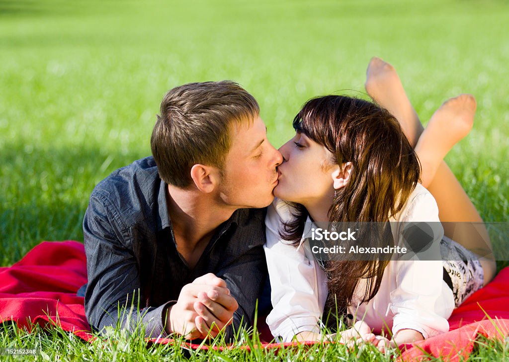 Romántico beso Pareja en el amor sobre el césped al aire libre - Foto de stock de Acostado libre de derechos