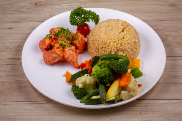 istock chicken tikka Quinoa in white plate on wooden background 1521523678