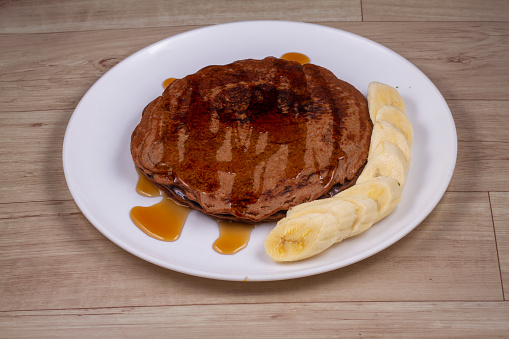 Chocolate Pancakes in white plate on wooden background