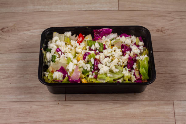 istock Greek Salad in black container on wooden background 1521525219