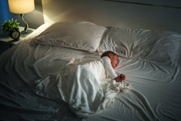infant baby sleeping on a bed at night