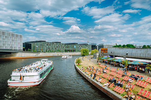 Tour boats with tourists and Modern office buildings along the Spree river, Germany\nNear Main Train Station and government district