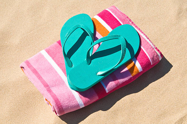 Flip-flops and towel at the beach. stock photo