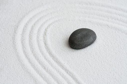 Zen Graden with Grey Stone on White Sand Line Texture Background, Top View Black Rock Sea Stone on Sand Wave Parallel Lines Pattern in Japanese stye, Banner for Harmony,Meditation,Zen like concept