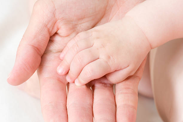 istock caucasian baby hand in father's palm 152157453