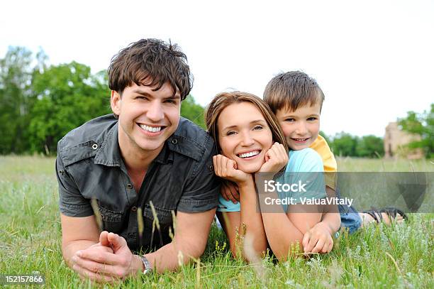 Family Lying On The Green Grass Stock Photo - Download Image Now - 25-29 Years, Adult, Beautiful People