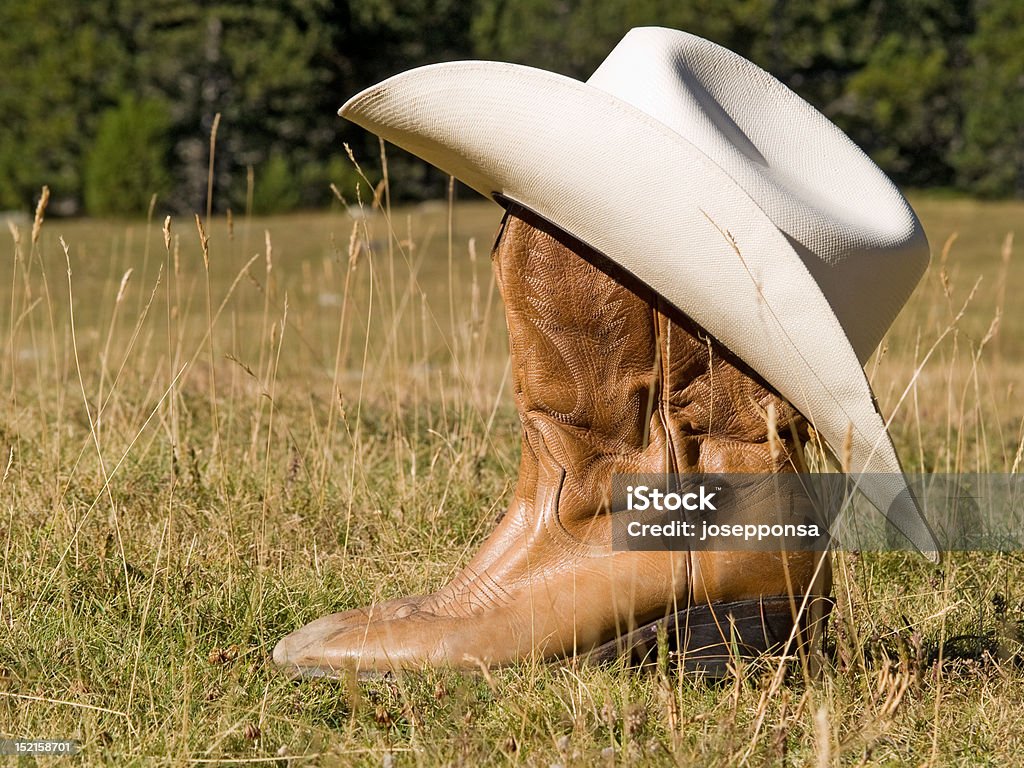 Botas de vaquero y sombrero en la naturaleza - Foto de stock de Accesorio de cabeza libre de derechos