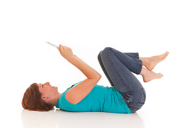 istock Young woman casually laying on floor with touchscreen computer 152159916