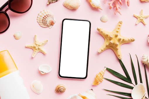 Flat lay composition with Phone and beach accessories on colored background. Smartphone with blank screen mock up with copy space.