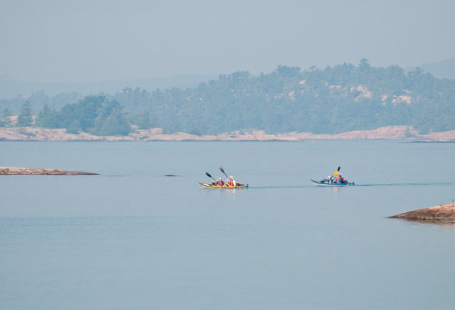 Group of kayakers paddling on a hot, hazy day in Georgian Bay, Ontario
