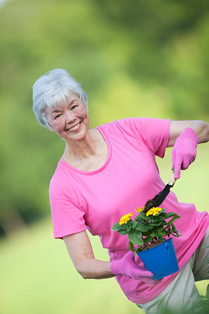 istock Older Woman Smiling & Working In Flower Garden 152163140