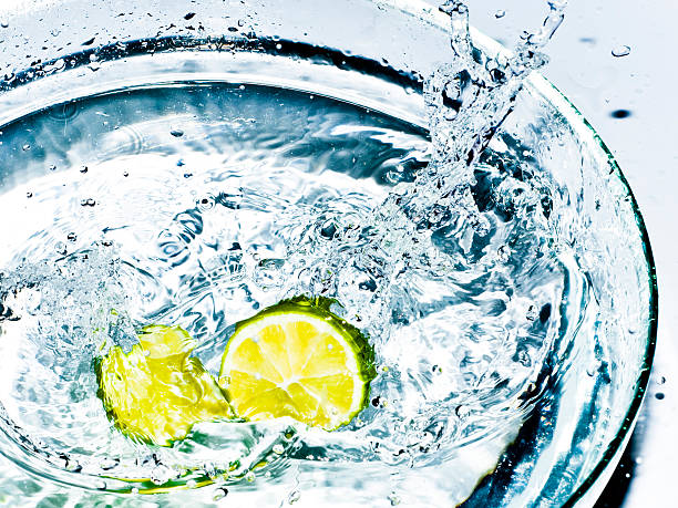 Bright yellow lemons splashing the water stock photo