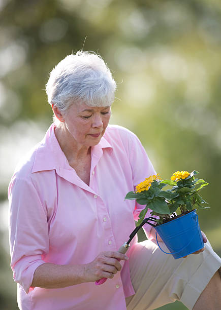 istock Mature Lady Planting Flowers 152165338