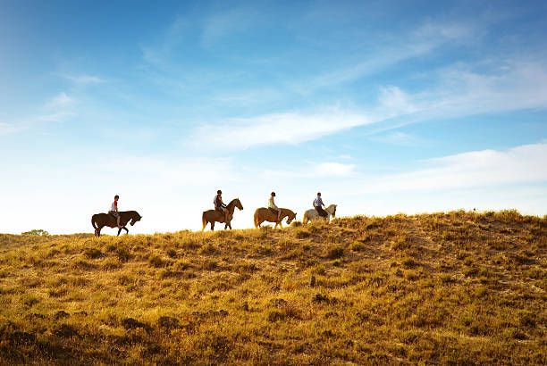 horseback riding horseback riding in the dunes near a beach at sunset all horse riding stock pictures, royalty-free photos & images