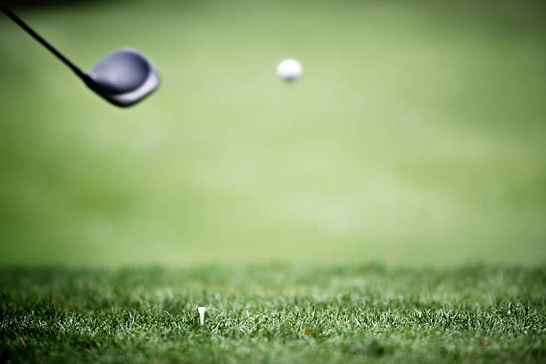 Golf background with driver and ball in air.