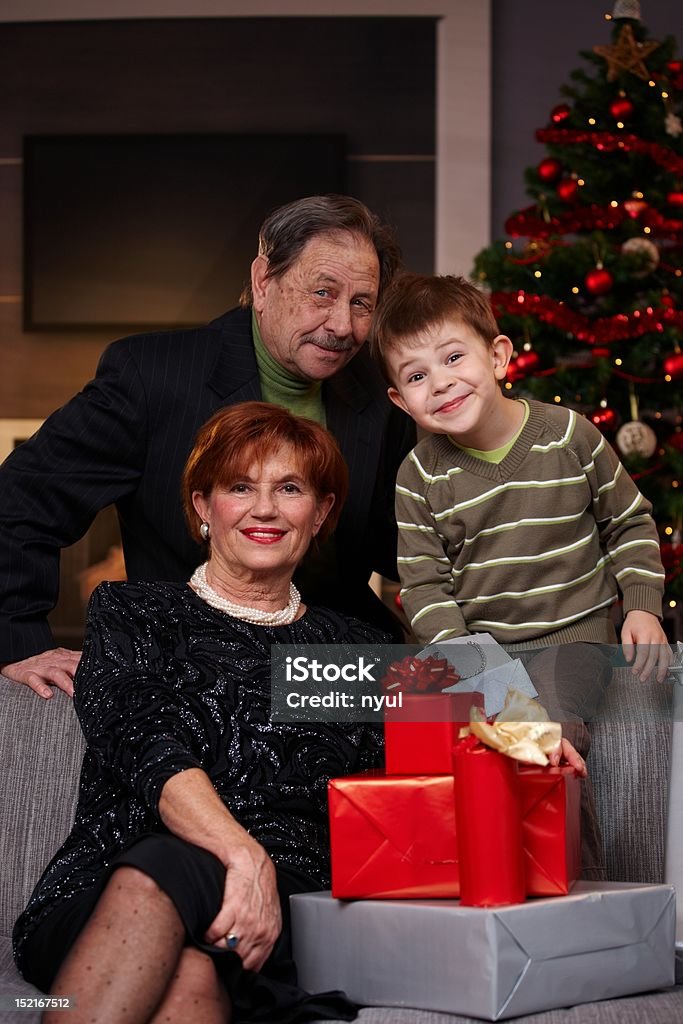 Portrait of grandparents and grandson at christmas Portrait of happy grandparents and grandson at christmas, smiling... 4-5 Years Stock Photo