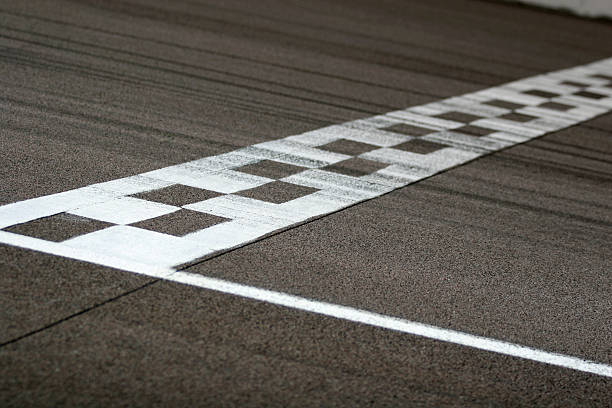 Race Track Start and Finish Line The painted start/finish line across the track at the Rockingham motor speedway in Northamptonshire, UK. Black tire marks are streaked across the track.  motor racing track photos stock pictures, royalty-free photos & images