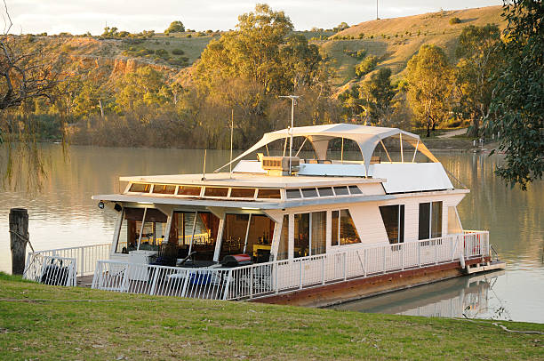Houseboat at sunset docked on River Murray, South Australia A Houseboat moored on the River Murray at Walker Flat in South Australia at sunset. Selective Focus. Others available in the series. houseboat photos stock pictures, royalty-free photos & images
