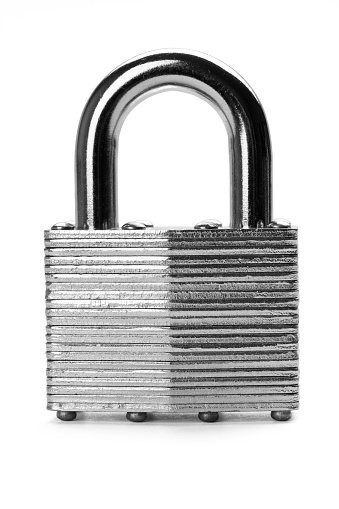 Padlock with red at symbol and silver shackle is securely locked with a gray key inserted into the keyhole, all set against a white backdrop that suggests a sense of safety and privacy. Fintech concept.