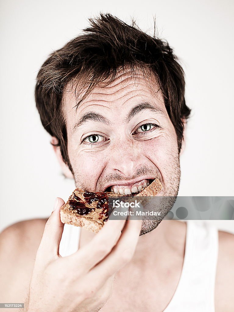 Homem comer Brinde com Manteiga de Amendoim e Geleia - Royalty-free Pão Foto de stock