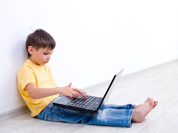 istock Little boy with laptop in empty room 152173423