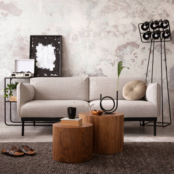 istock Creative composition of indiustral and loft living room interior with mock up poster frame, gray sofa, round coffee table, brown leather armchairs, plaid, pillows and personal accessories. Home decor. Template. 1521736789