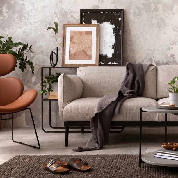 istock Creative composition of indiustral and loft living room interior with mock up poster frame, gray sofa, round coffee table, brown leather armchairs, plaid, pillows and personal accessories. Home decor. Template. 1521736794