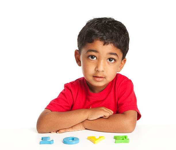 Toddler Spelling the letter Love on a White Board stock photo