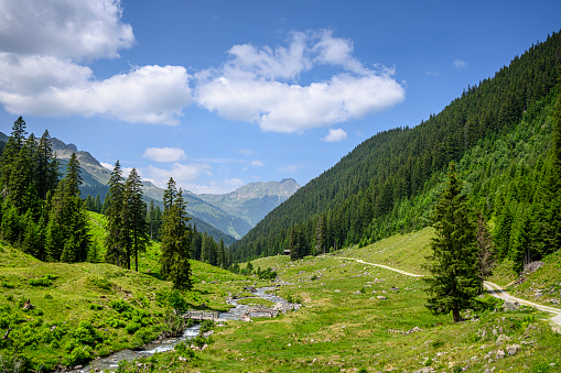 Beautiful landscape with a winding mountain road and a winding stream. Silbertal, Montafon, Vorarlberg