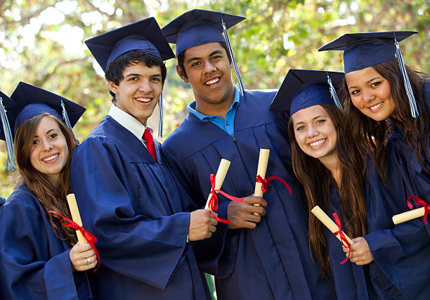 istock Graduating students in blue robes holding diplomas 152175482