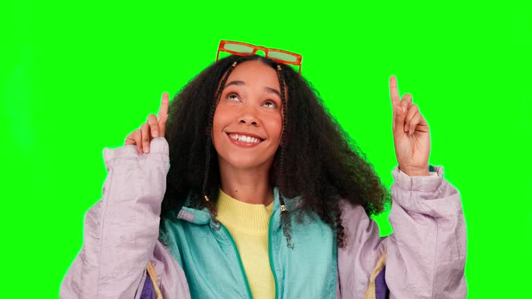 Face, green screen and woman pointing up, emoji and happiness with lady on a studio background. Portrait, female person and girl with joy, hand gesture and retro with opportunity, choice and decision