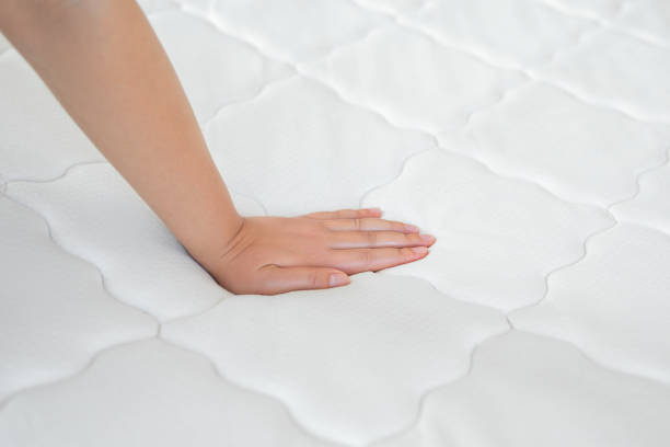 istock Woman hand testing orthopedic memory foam core mattress 1521771002