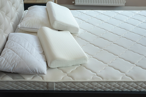 Comfortable bed with soft white mattress and pillows