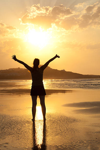 istock woman enjoying sun in a deserted beach at sunset 152177242