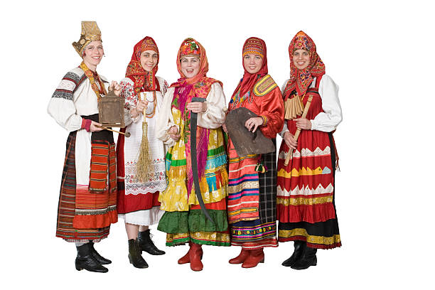 Women musicians in Russian folk dresses with musical instruments on a yellow studio background. Happy artists from Russia in national clothes with stringed musical instruments with smiles on faces