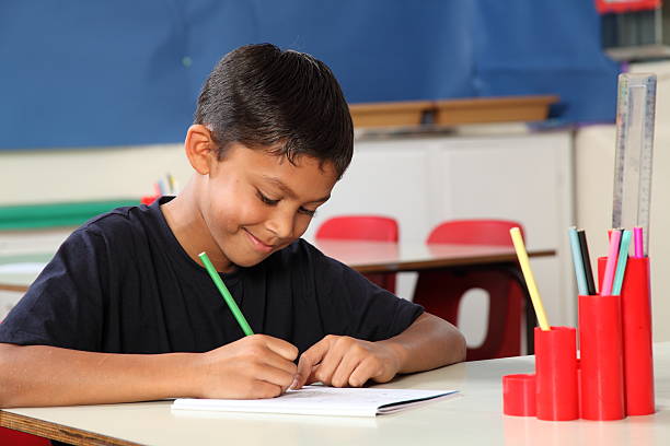 istock Young school boy 10 writing at his classroom desk 152177727