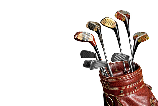 Vintage worn Golf clubs in an old bag isolated over a white background with a clipping path