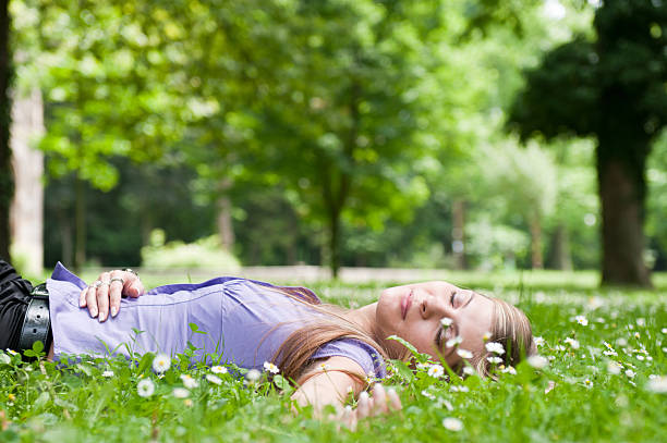 istock Young woman lying in grass with flowers 152178664